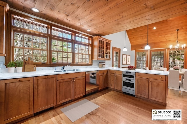 kitchen with kitchen peninsula, hanging light fixtures, light hardwood / wood-style flooring, dishwasher, and wood ceiling