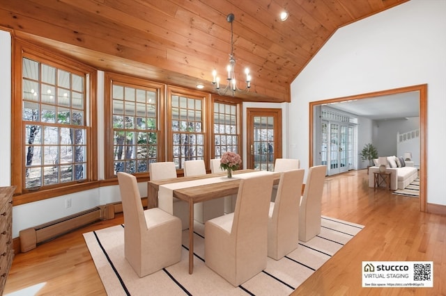 dining area featuring light hardwood / wood-style flooring, a wealth of natural light, a notable chandelier, and lofted ceiling