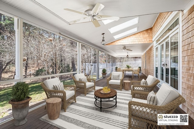 sunroom / solarium with ceiling fan and vaulted ceiling with skylight