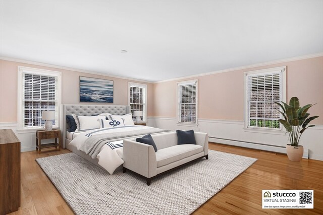 bedroom featuring baseboard heating, light hardwood / wood-style flooring, and crown molding