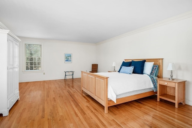 bedroom with ornamental molding and light hardwood / wood-style flooring