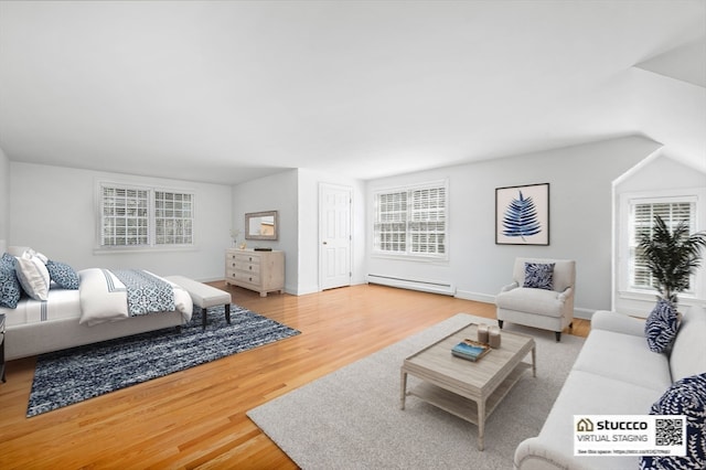 bedroom featuring a baseboard heating unit and light hardwood / wood-style flooring