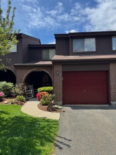 51 Tamarack Ln Unit 51, Peabody, MA 01960 - view of front of home featuring brick siding, asphalt driveway, a garage, and a front lawn