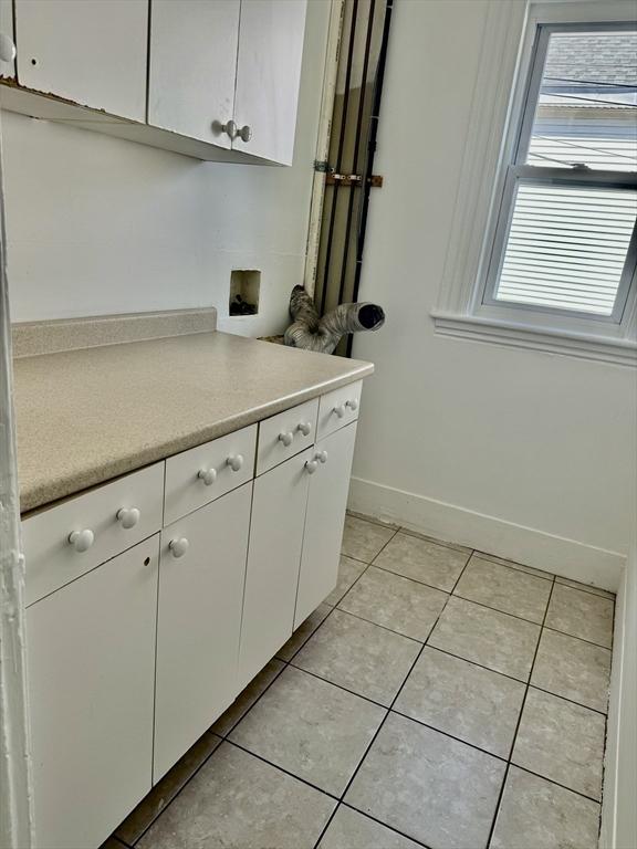 437 Ferry St Unit 1, Everett, MA 02149 - kitchen with light tile patterned floors, light countertops, and white cabinetry
