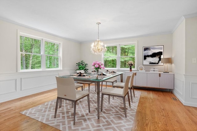 32 Twin Pond Ln, Sudbury, MA 01776 - dining area with a chandelier, ornamental molding, light wood finished floors, a decorative wall, and a wainscoted wall