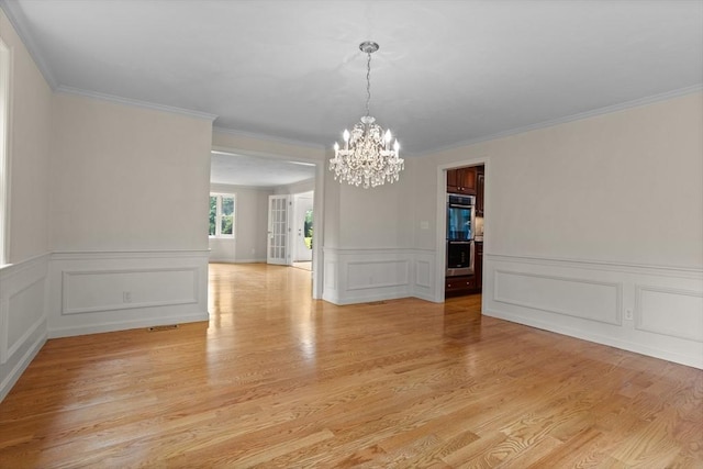 32 Twin Pond Ln, Sudbury, MA 01776 - spare room with a chandelier, light wood-type flooring, a decorative wall, crown molding, and a wainscoted wall