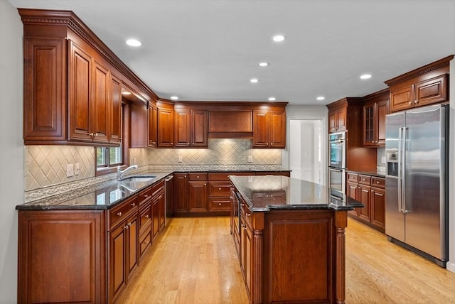 32 Twin Pond Ln, Sudbury, MA 01776 - kitchen featuring appliances with stainless steel finishes, light wood-type flooring, recessed lighting, dark stone countertops, and a center island