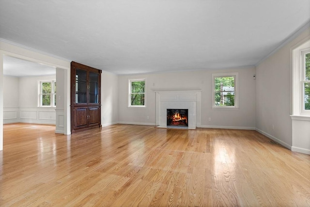 32 Twin Pond Ln, Sudbury, MA 01776 - unfurnished living room with light wood-style flooring, a lit fireplace, and ornamental molding