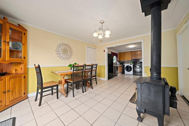 24 Hobson St, Brockton, MA 02302 - dining space featuring washer / clothes dryer, a wood stove, light tile patterned flooring, ornamental molding, and baseboards