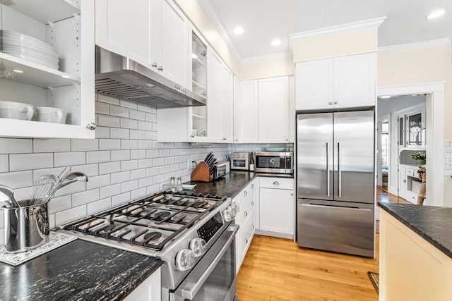 kitchen with white cabinetry, stainless steel appliances, crown molding, and range hood