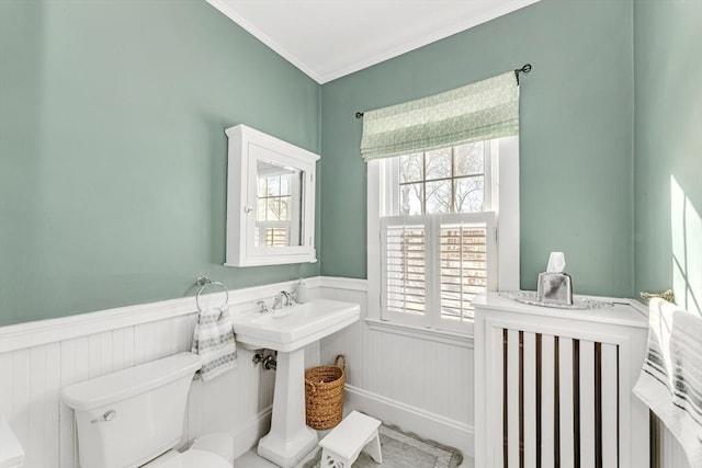 bathroom featuring ornamental molding and toilet