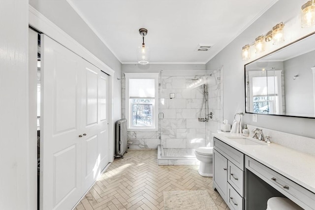 bathroom with radiator, crown molding, vanity, a shower with shower door, and toilet