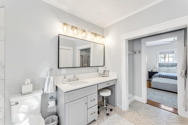 bathroom with crown molding, parquet flooring, vanity, and toilet