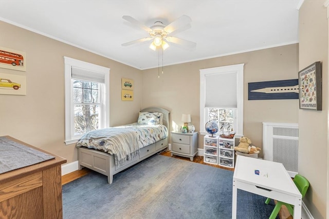 bedroom featuring radiator heating unit, wood-type flooring, and ceiling fan