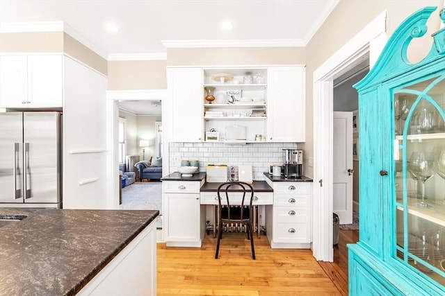 bar featuring light hardwood / wood-style flooring, high end fridge, backsplash, white cabinetry, and dark stone counters