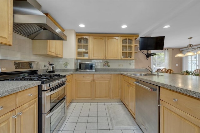 kitchen with sink, wall chimney exhaust hood, light brown cabinets, light tile patterned flooring, and appliances with stainless steel finishes