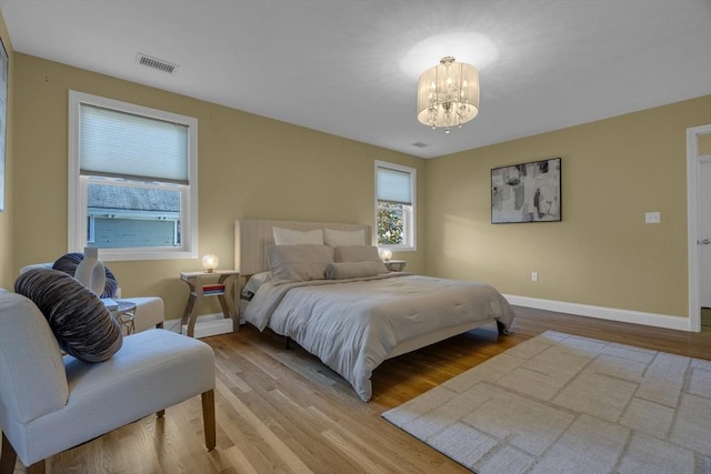 bedroom featuring a chandelier and light hardwood / wood-style floors