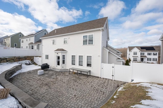 snow covered house featuring a patio