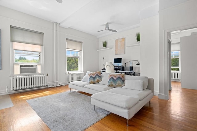 living room featuring ceiling fan, radiator, and plenty of natural light