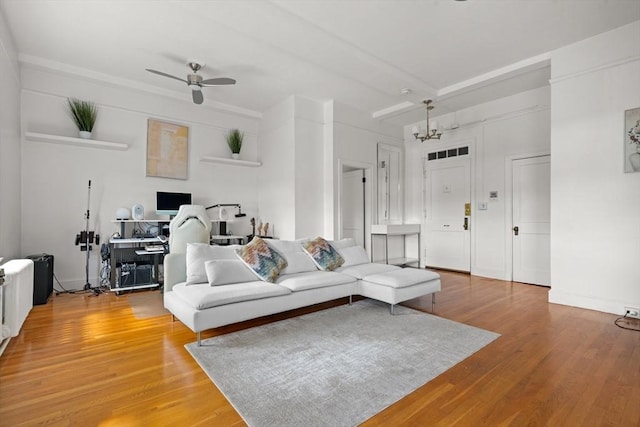 living room with ceiling fan with notable chandelier, beamed ceiling, and wood-type flooring