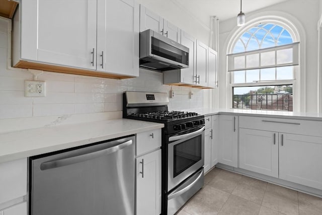 kitchen featuring stainless steel appliances, white cabinetry, decorative light fixtures, and decorative backsplash