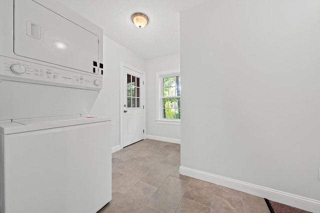 laundry room with stacked washer / drying machine and light tile patterned floors