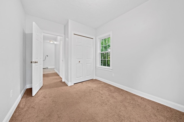 unfurnished bedroom featuring a closet and light carpet