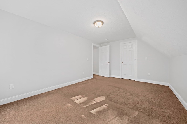 bonus room featuring carpet, a textured ceiling, and lofted ceiling