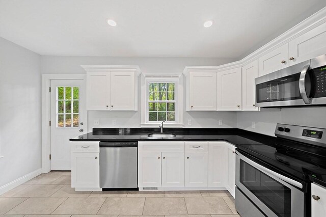 kitchen featuring sink, stainless steel appliances, white cabinetry, and a wealth of natural light