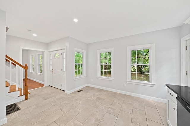 foyer featuring light tile patterned flooring and a healthy amount of sunlight