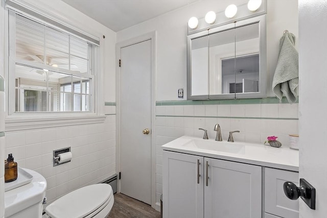 30 Brigham St, Hudson, MA 01749 - bathroom featuring tile walls, vanity, wood finished floors, and a baseboard radiator