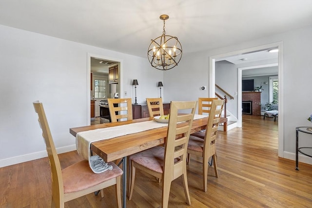30 Brigham St, Hudson, MA 01749 - dining room featuring a chandelier, light wood-style floors, stairway, and a fireplace