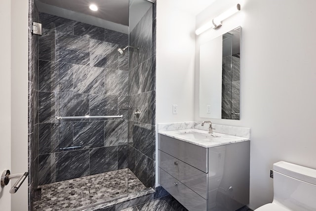 bathroom featuring tiled shower, vanity, and toilet