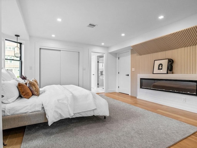 8 Wiswall Unit 8, Wellesley, MA 02482 - bedroom featuring wood finished floors, recessed lighting, a glass covered fireplace, and a closet