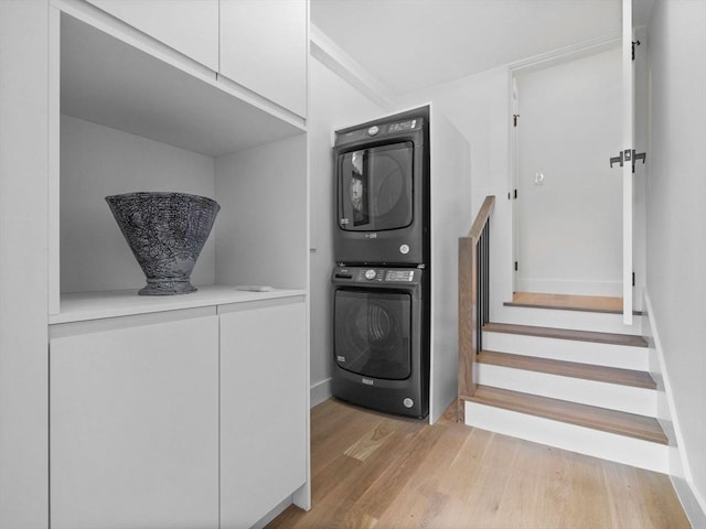 8 Wiswall Unit 8, Wellesley, MA 02482 - laundry area with stacked washer and clothes dryer, light wood-style flooring, cabinet space, and baseboards