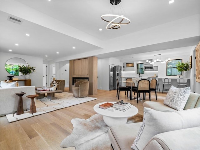 8 Wiswall Unit 8, Wellesley, MA 02482 - living area with a chandelier, light wood-style flooring, recessed lighting, and a large fireplace
