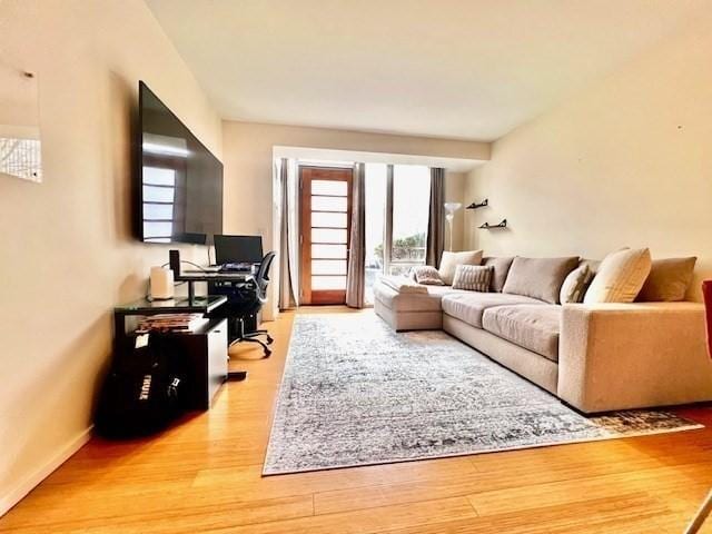 2 Earhart Unit 121, Cambridge, MA 02141 - living room featuring an office area, light wood-style flooring, and baseboards