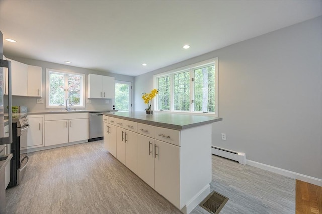 56 Burt St, Norton, MA 02766 - kitchen with baseboard heating, appliances with stainless steel finishes, light wood-type flooring, a kitchen island, and recessed lighting