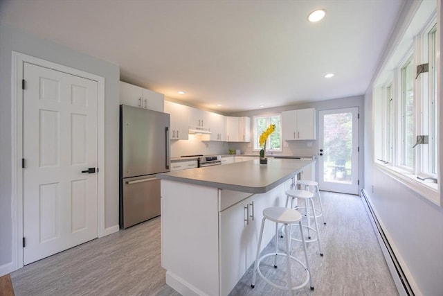 56 Burt St, Norton, MA 02766 - kitchen featuring appliances with stainless steel finishes, baseboard heating, light wood finished floors, white cabinetry, and recessed lighting
