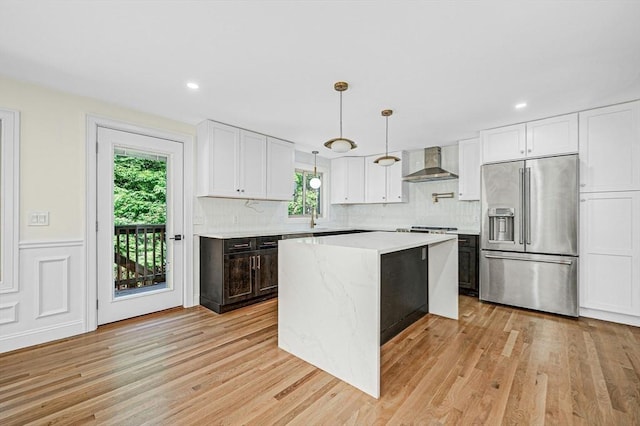 30 Twilight Dr, Foxboro, MA 02035 - kitchen with high end refrigerator, wall chimney range hood, light wood-style flooring, white cabinetry, and decorative backsplash