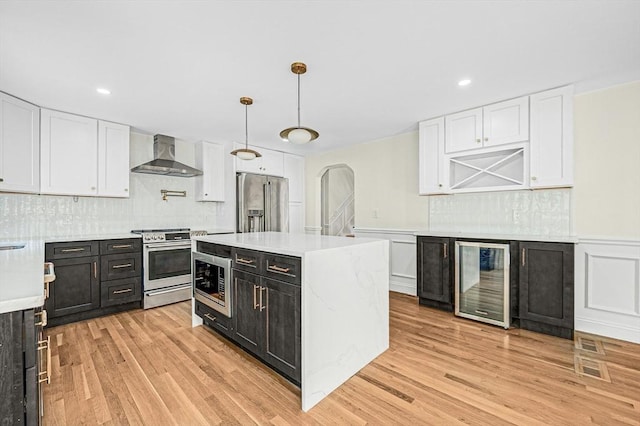 30 Twilight Dr, Foxboro, MA 02035 - kitchen with wine cooler, appliances with stainless steel finishes, wall chimney range hood, dark cabinets, and white cabinetry