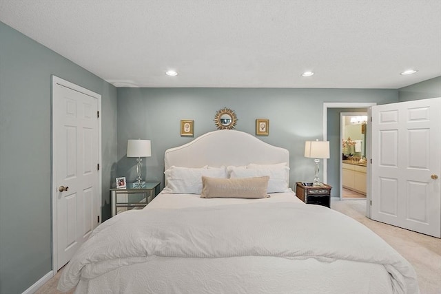 bedroom featuring light carpet, recessed lighting, and connected bathroom