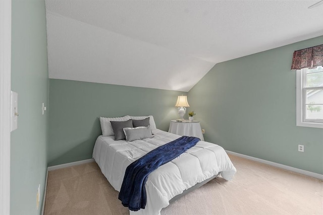 bedroom with light carpet, lofted ceiling, and baseboards