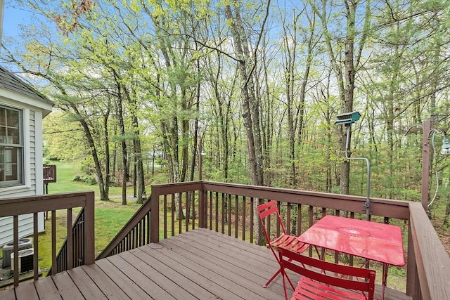 wooden terrace with central air condition unit and a yard