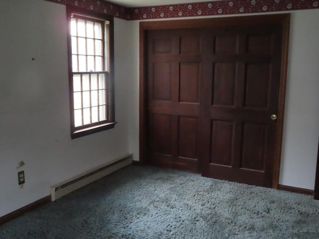 unfurnished bedroom with carpet flooring, baseboard heating, and baseboards