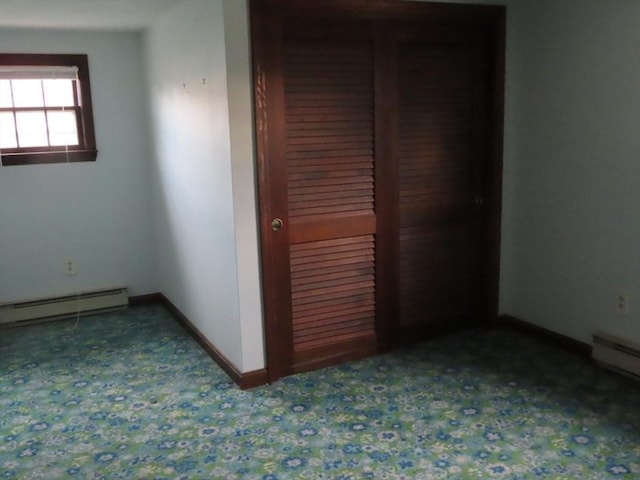 unfurnished bedroom with a baseboard radiator, baseboards, and a closet