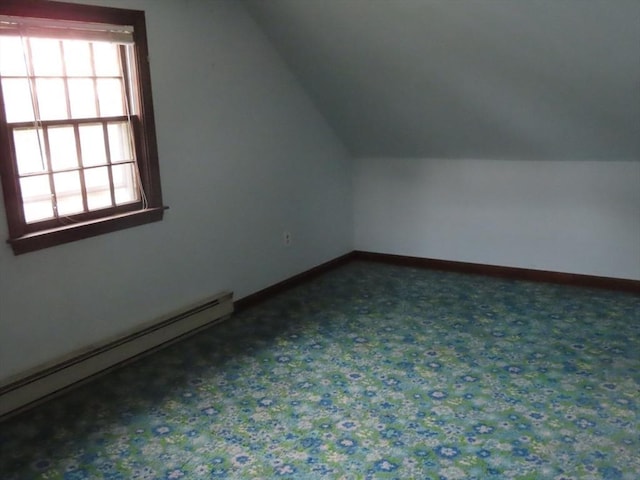 additional living space with baseboards, vaulted ceiling, dark colored carpet, and a baseboard radiator
