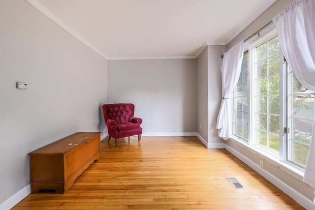 unfurnished room with light hardwood / wood-style flooring, plenty of natural light, and crown molding