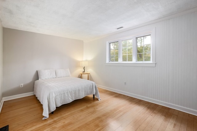 bedroom featuring a textured ceiling and hardwood / wood-style flooring