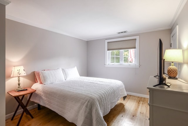 bedroom featuring light hardwood / wood-style flooring and ornamental molding